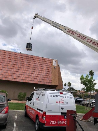 Alpha Air truck and crane placing an AC unit on a roof in Las Vegas.